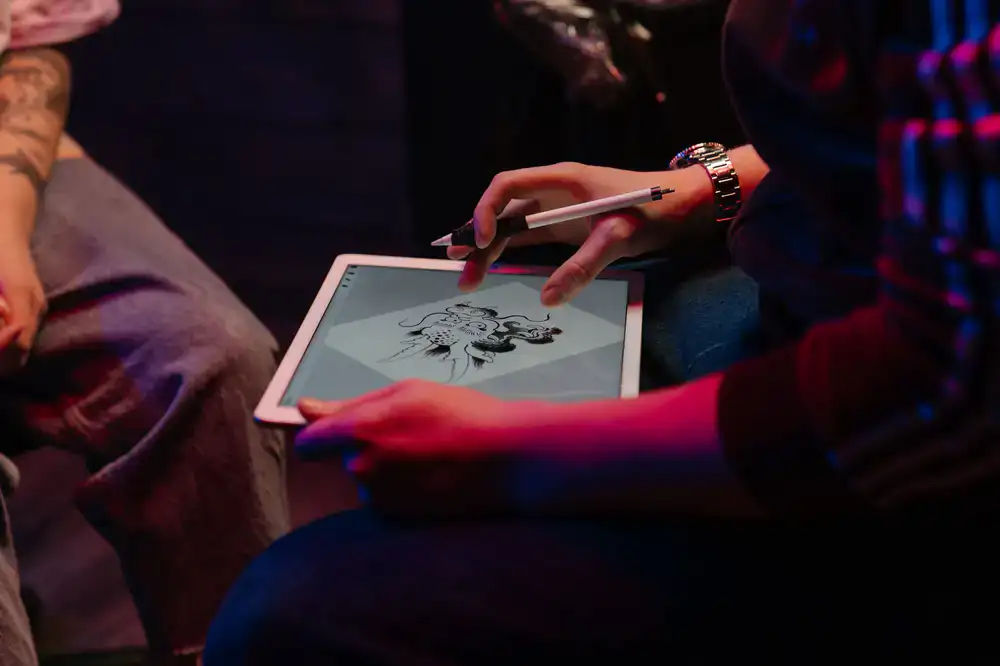 Game designers sketching colorful fish characters on digital tablets